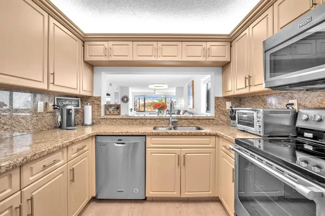 a kitchen with stainless steel appliances granite countertop a sink and cabinets