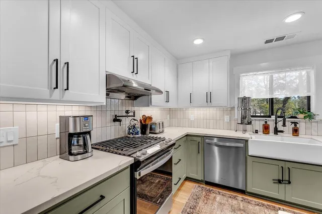 a kitchen with a stove sink and cabinets
