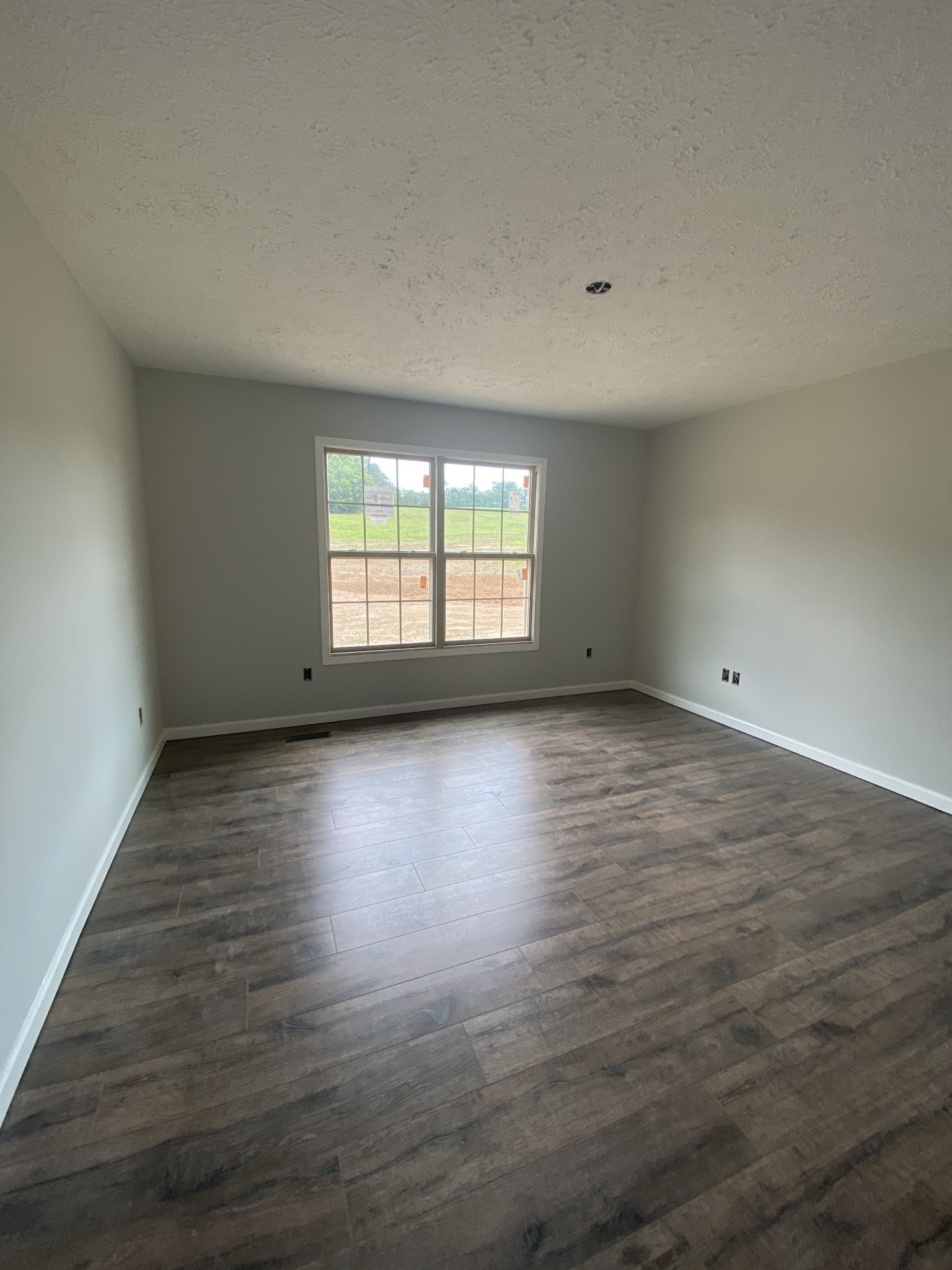 767 Jarrell Road Manchester, TN 37355 - Photo 6 of 8 a view of an empty room with wooden floor and a window