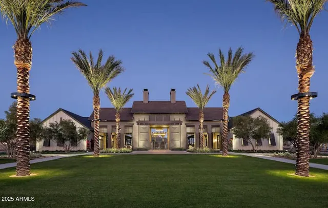 a front view of a house with a garden and tree