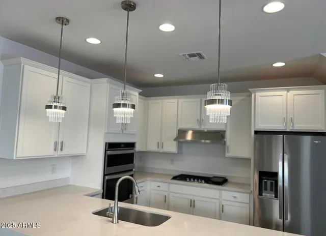 a kitchen with kitchen island a counter space a sink and appliances