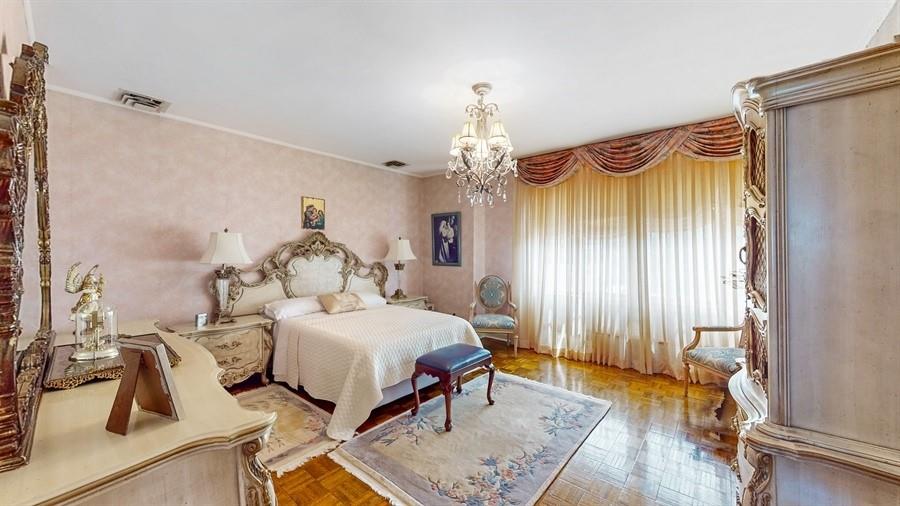 169 84th Street Brooklyn, NY 11209 - Photo 18 of 40 a bedroom with a bed and a chandelier
