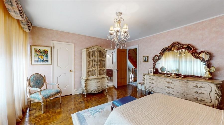 169 84th Street Brooklyn, NY 11209 - Photo 19 of 40 a spacious bedroom with a bed a chandelier and dresser