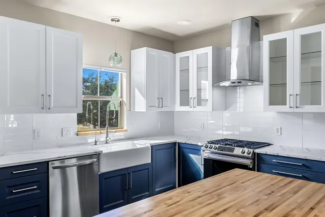 a kitchen with stainless steel appliances a sink stove and cabinets