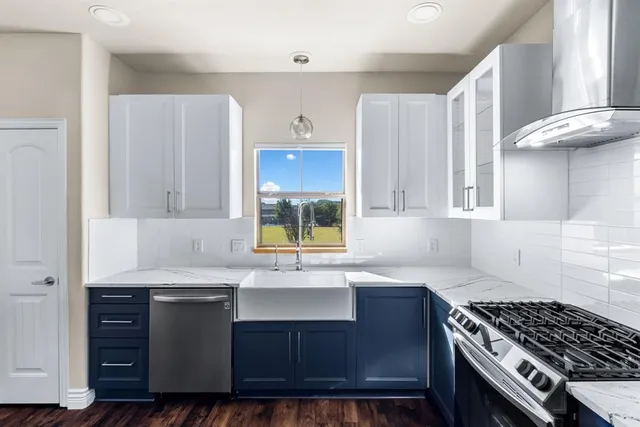 a kitchen with granite countertop a sink stove and cabinets