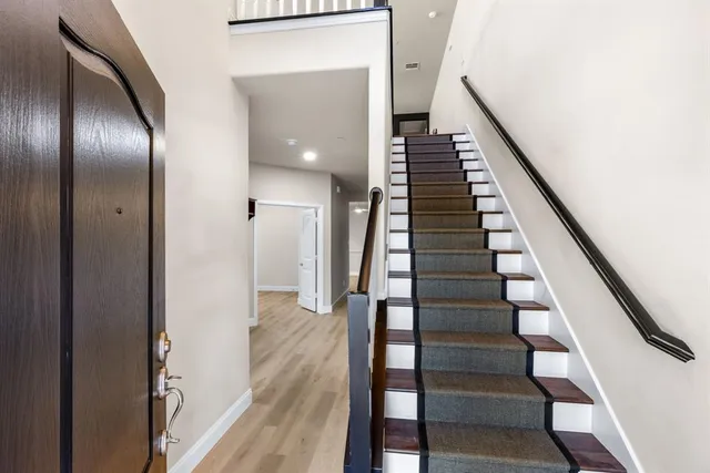 a view of a hallway with wooden floor and stairs