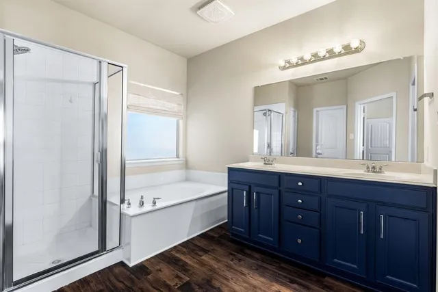 a bathroom with a tub a double vanity sink and mirror