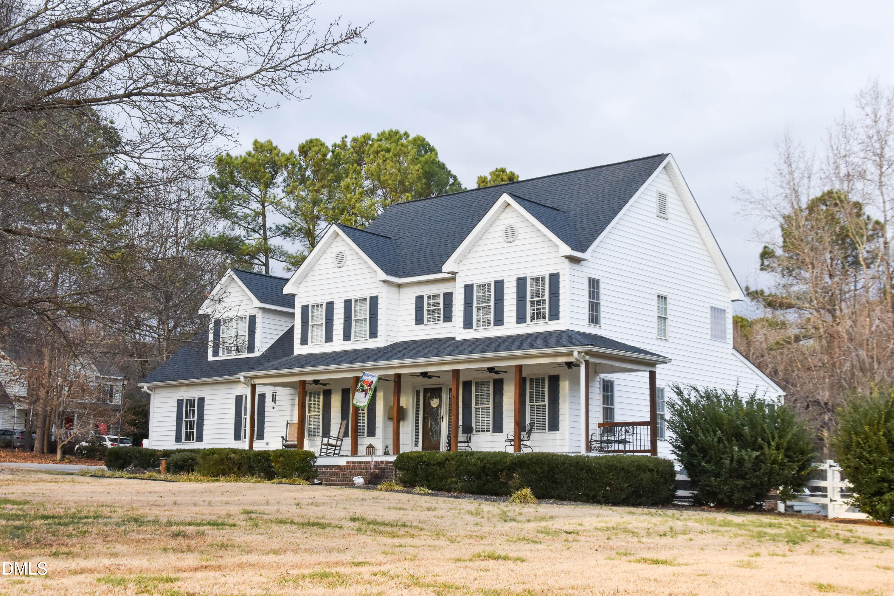 a front view of a house with a yard and lake view