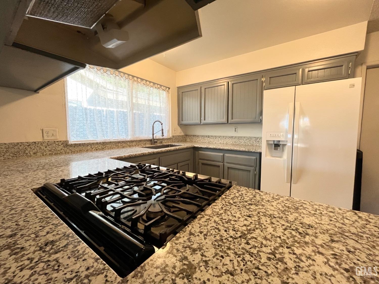 Undisclosed Address Bakersfield, CA 93304 - Photo 12 of 33 a kitchen with a stove a refrigerator and a window