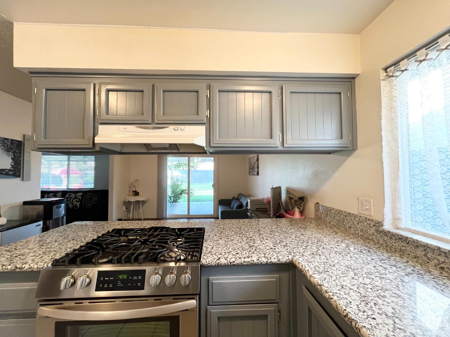 Undisclosed Address Bakersfield, CA 93304 - Photo 14 of 33 a kitchen with granite countertop a stove and cabinets