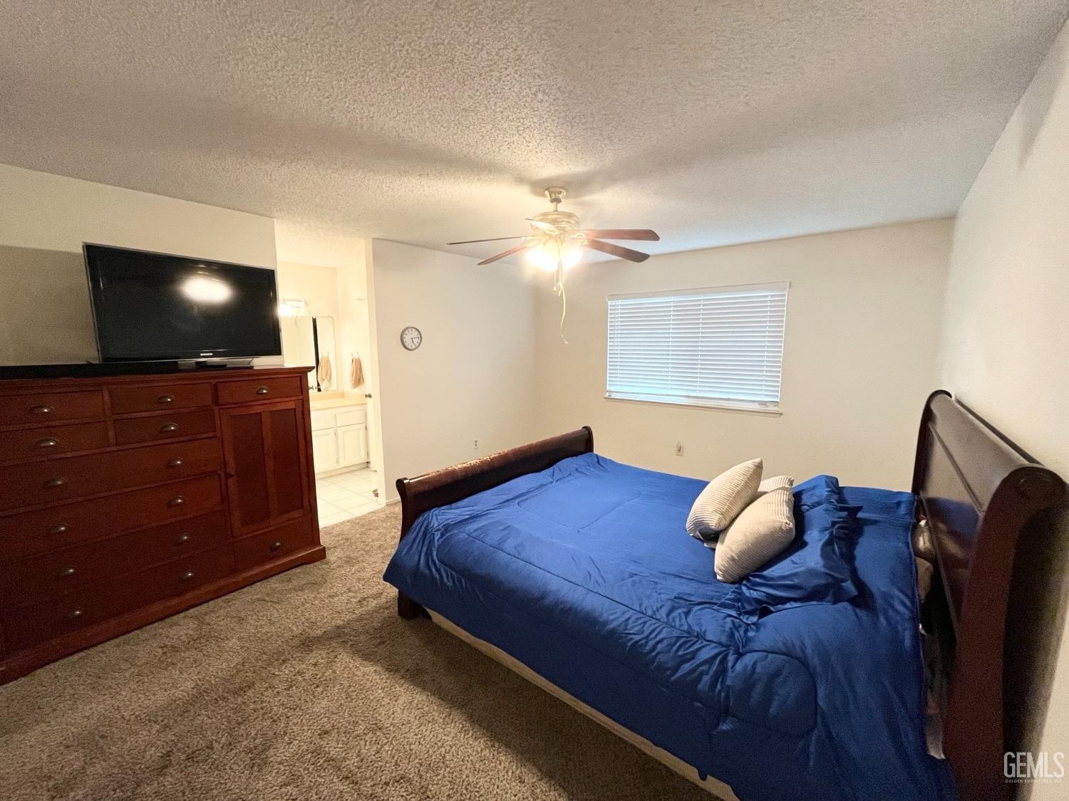 Undisclosed Address Bakersfield, CA 93304 - Photo 18 of 33 a bedroom with a bed and a flat tv screen on dresser