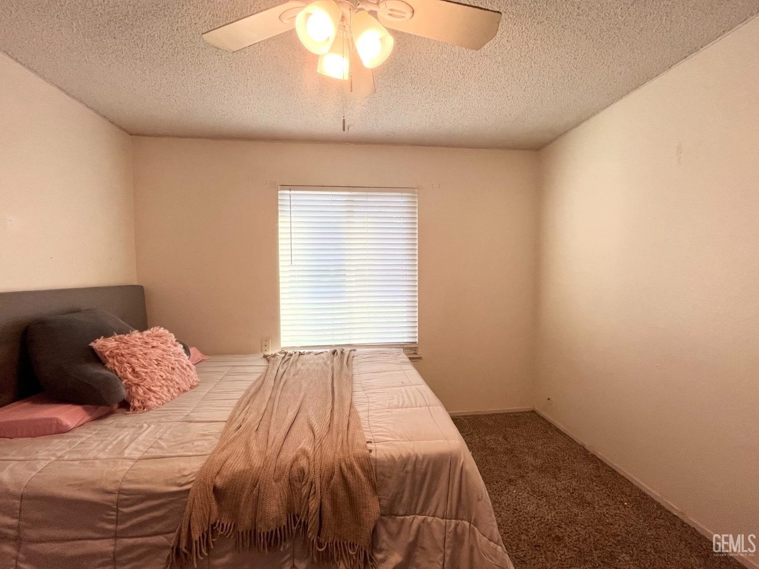 Undisclosed Address Bakersfield, CA 93304 - Photo 24 of 33 a bedroom with a bed and a chandelier