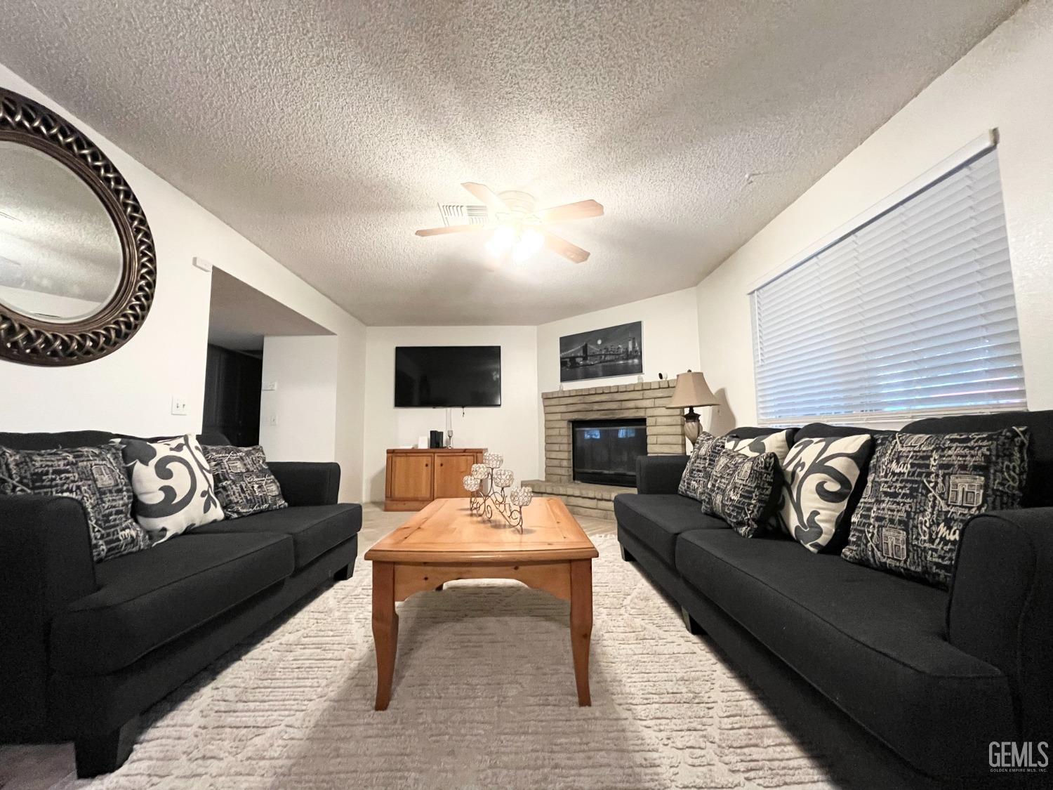 Undisclosed Address Bakersfield, CA 93304 - Photo 10 of 33 a living room with furniture and a fireplace