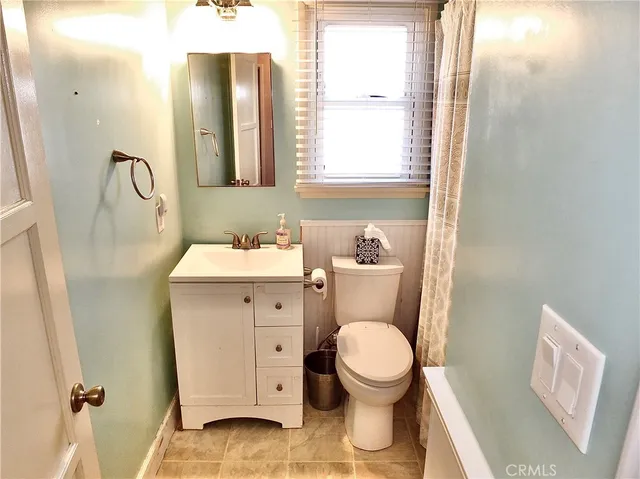 a bathroom with a toilet sink and a mirror