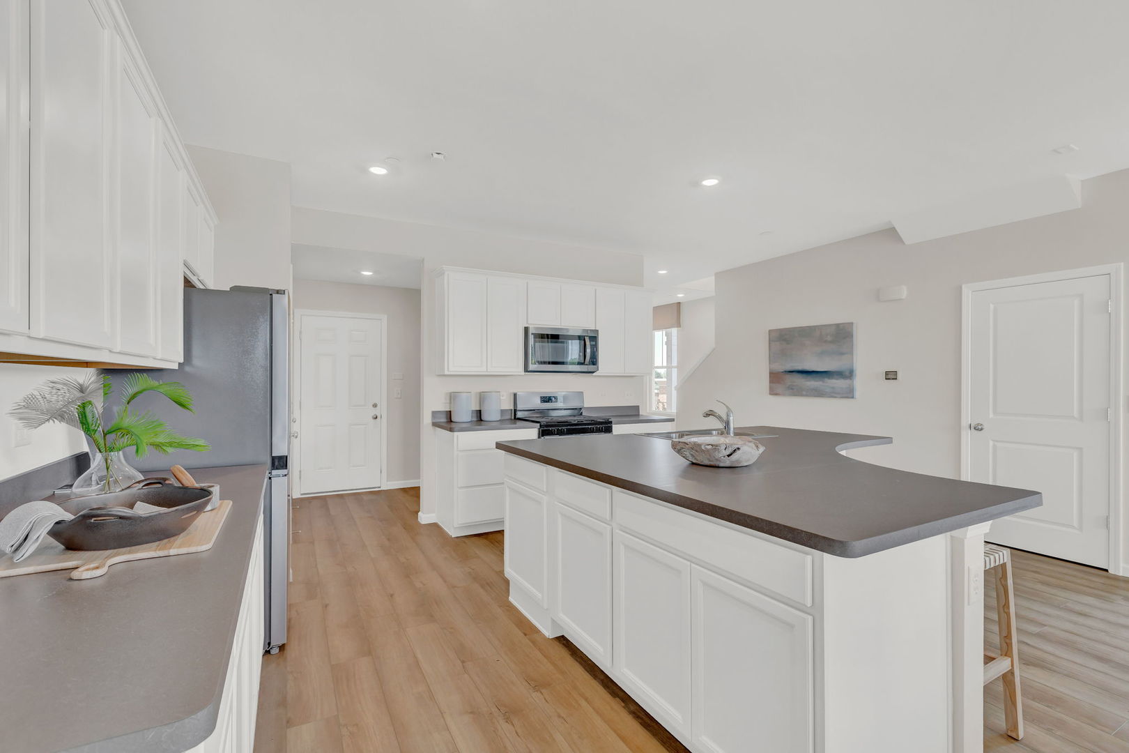 5913 Hawkweed Drive, Unit 8704 Plainfield, IL 60585 - Photo 7 of 17 a kitchen with stainless steel appliances granite countertop a sink stove and refrigerator