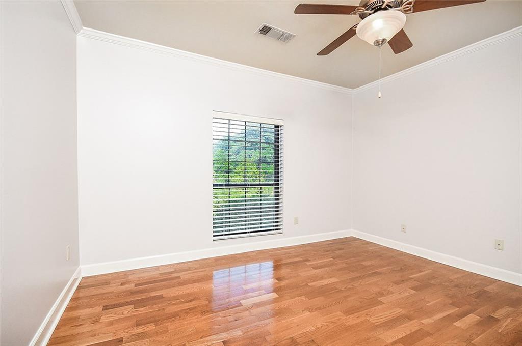 2865 Lenox Road Northeast, Unit 407 Atlanta, GA 30324 - Photo 21 of 27 a view of an empty room with wooden floor and a window