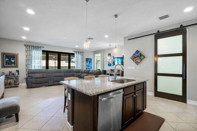 a kitchen with stainless steel appliances granite countertop a sink and a refrigerator