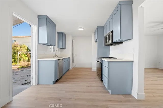 a kitchen with stainless steel appliances granite countertop a sink and a stove top oven