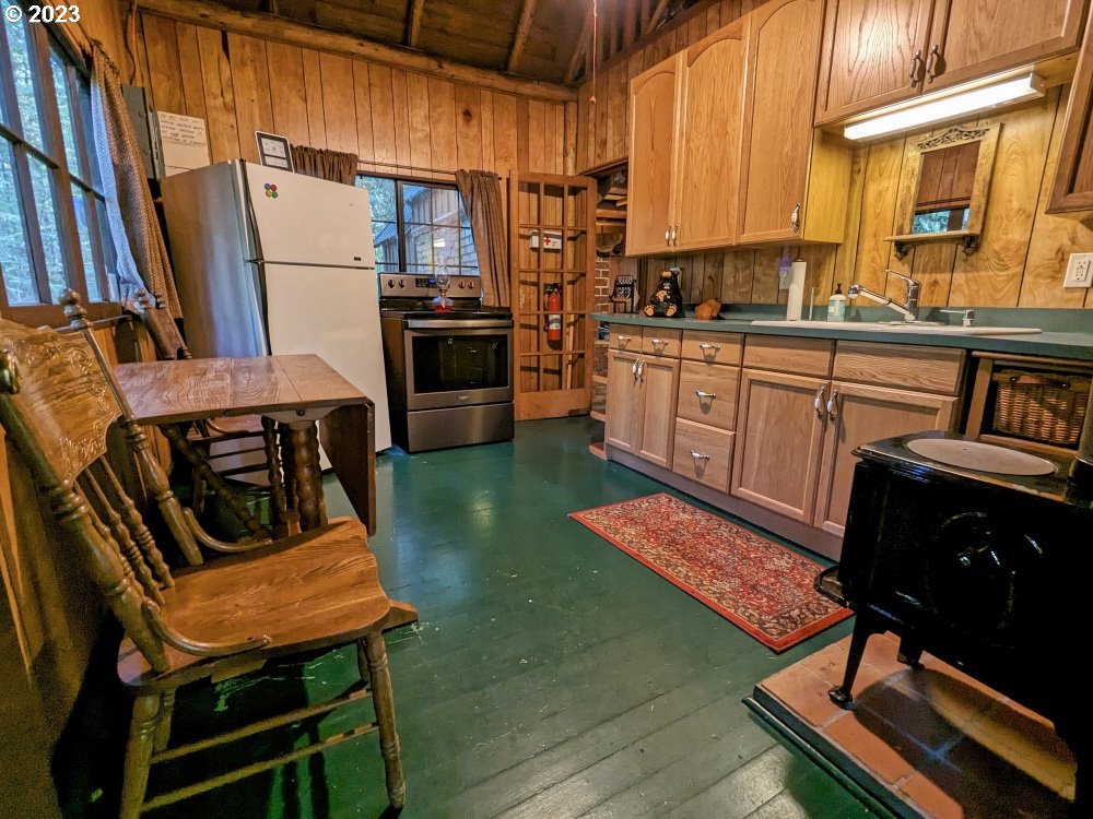 79128 Road 35 A Rhododendron, OR 97049 - Photo 20 of 36 a kitchen with stainless steel appliances a stove a sink dishwasher and cabinets