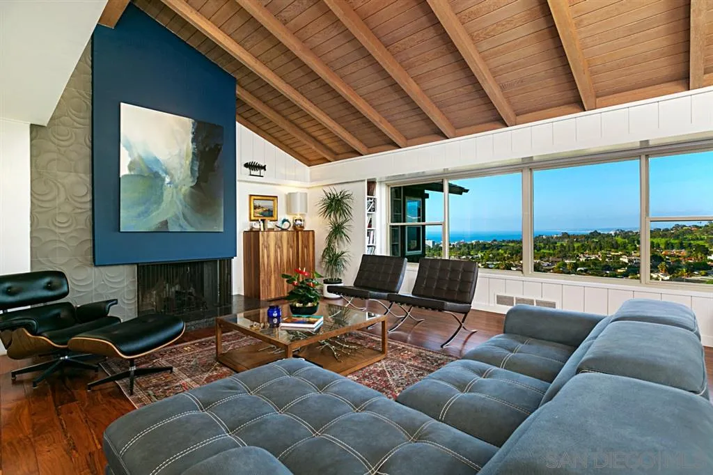 1106 Muirlands Drive La Jolla, CA 92037 - Photo 4 of 24 a living room with furniture a lamp wooden floor and a large window