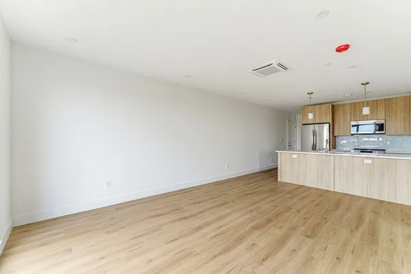 a view of kitchen with wooden floor and electronic appliances