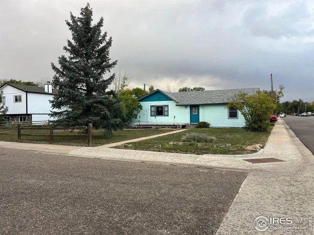 a view of yellow house with a yard