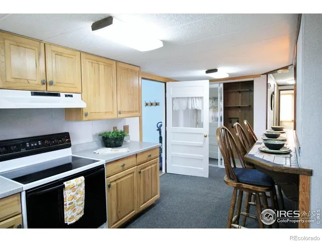 a kitchen with stainless steel appliances kitchen island granite countertop a stove refrigerator and cabinets