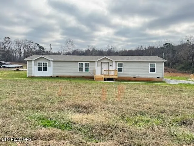 a view of a house with a big yard and large trees