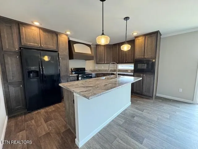 a kitchen with a sink a refrigerator and a stove top oven