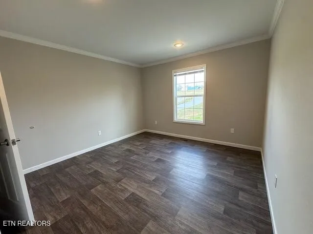 an empty room with wooden floor and window