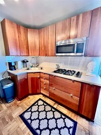a kitchen with stainless steel appliances granite countertop a stove a sink dishwasher and cabinets with wooden floor