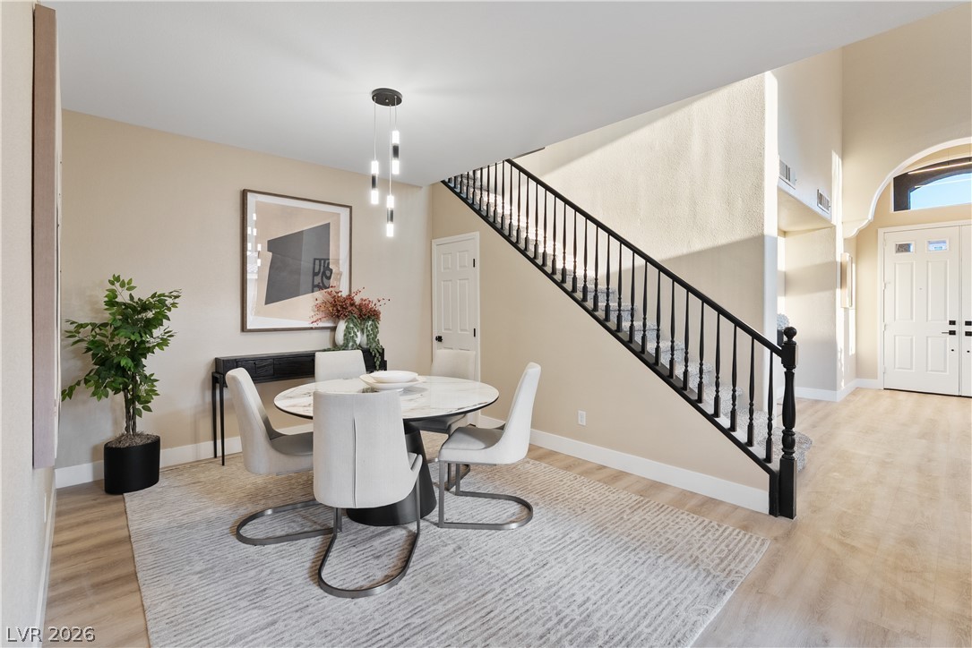 1662 Ravanusa Drive Henderson, NV 89052 - Photo 50 of 74 An inviting dining area flows seamlessly into the entry, featuring light wood flooring and a graceful staircase.