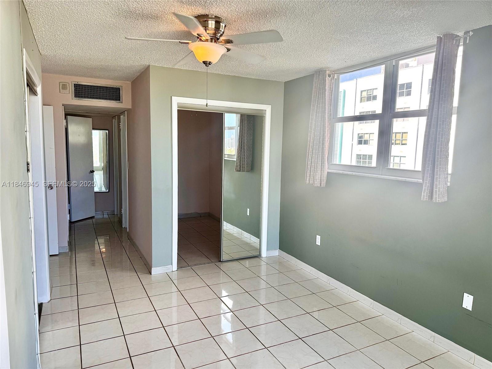 1228 West Avenue, Unit 1109 Miami Beach, FL 33139 - Photo 3 of 10 a view of an empty room with window and chandelier fan