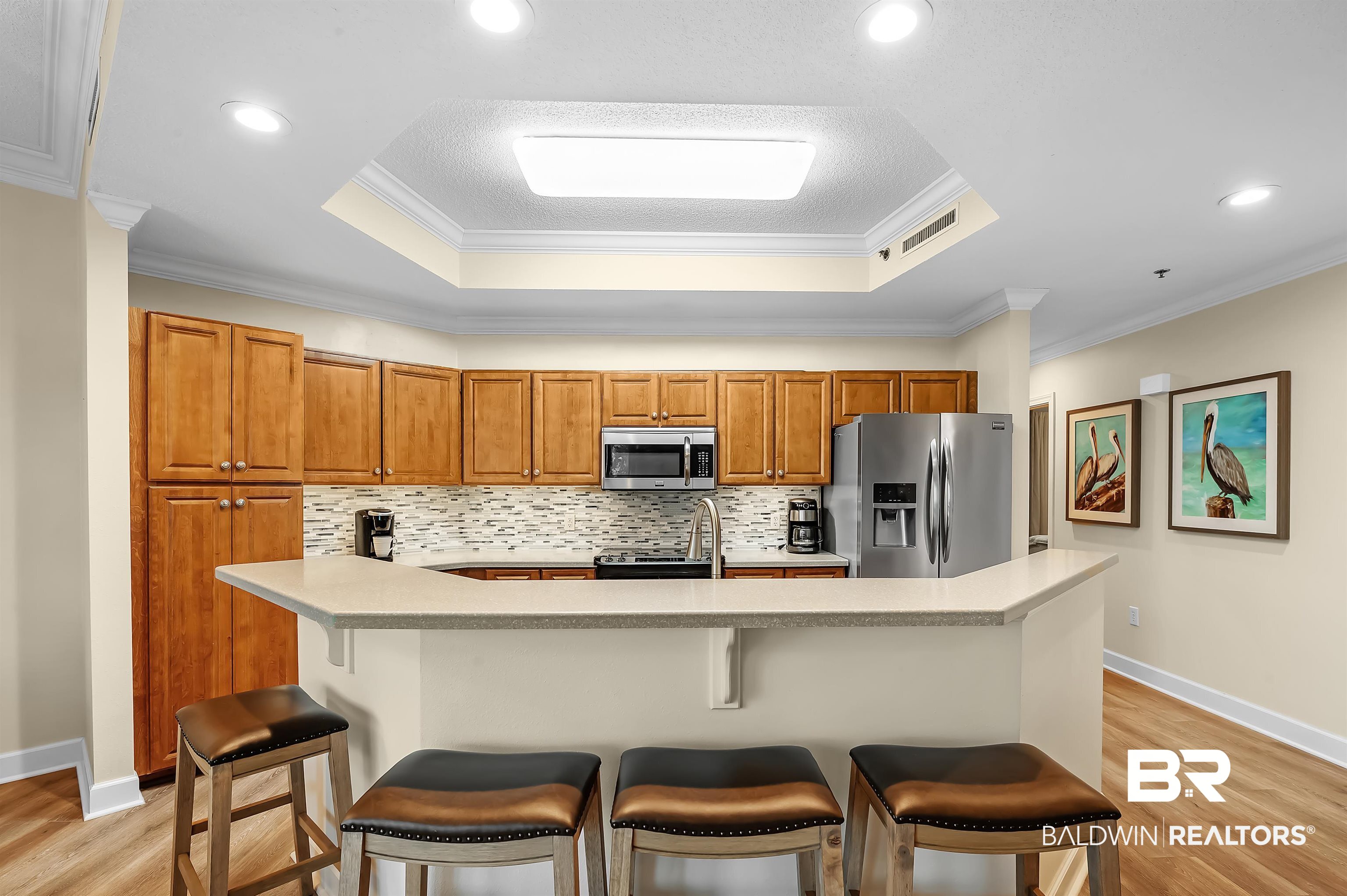 27582 Canal Road, Unit 2104 Orange Beach, AL 36561 - Photo 15 of 35 Kitchen featuring light hardwood / wood-style flooring, stainless steel appliances, a raised ceiling, and crown molding
