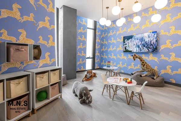 a living room with furniture and a baby crib