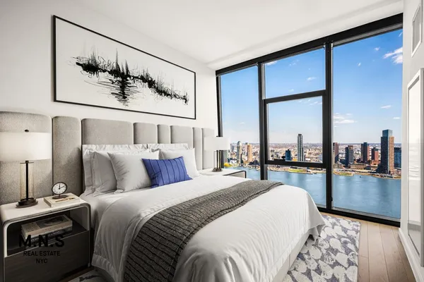 a bedroom with a large bed and a chandelier