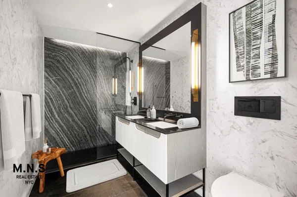 a bathroom with a sink a toilet and a mirror