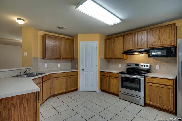 a kitchen with stainless steel appliances granite countertop wooden cabinets a stove top oven a sink and dishwasher