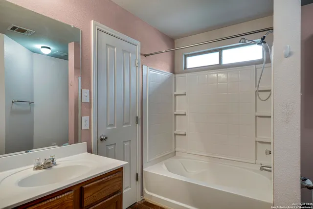 a bathroom with a bathtub shower sink vanity and a toilet