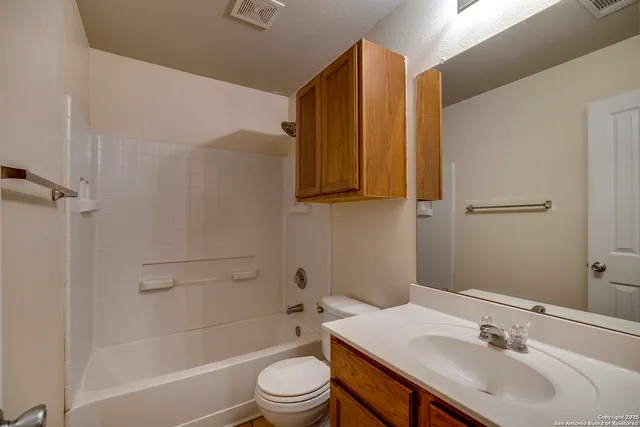 a view of an empty room with window and chandelier fan