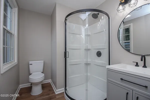 a bathroom with a toilet a sink and mirror