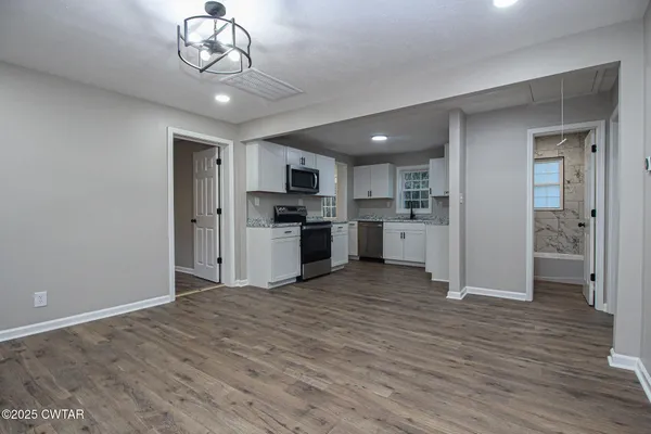 a view of kitchen with refrigerator microwave and cabinets