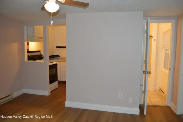 a view of a hallway with wooden floor and a dining room