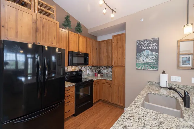 a kitchen with stainless steel appliances granite countertop a refrigerator and a sink
