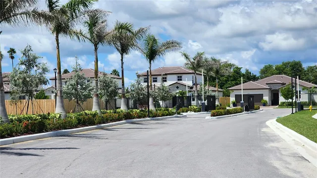 a front view of a house with palm trees