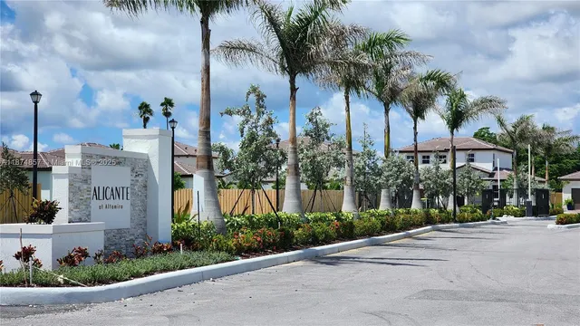 a front view of multi story residential apartment building with yard and sign board