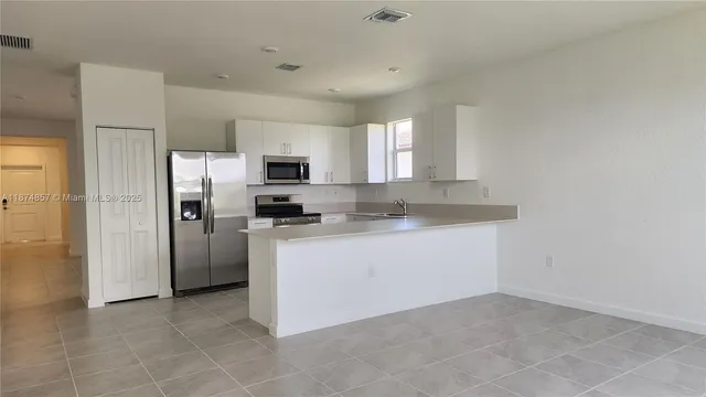 a kitchen with a refrigerator a microwave a sink and a stove