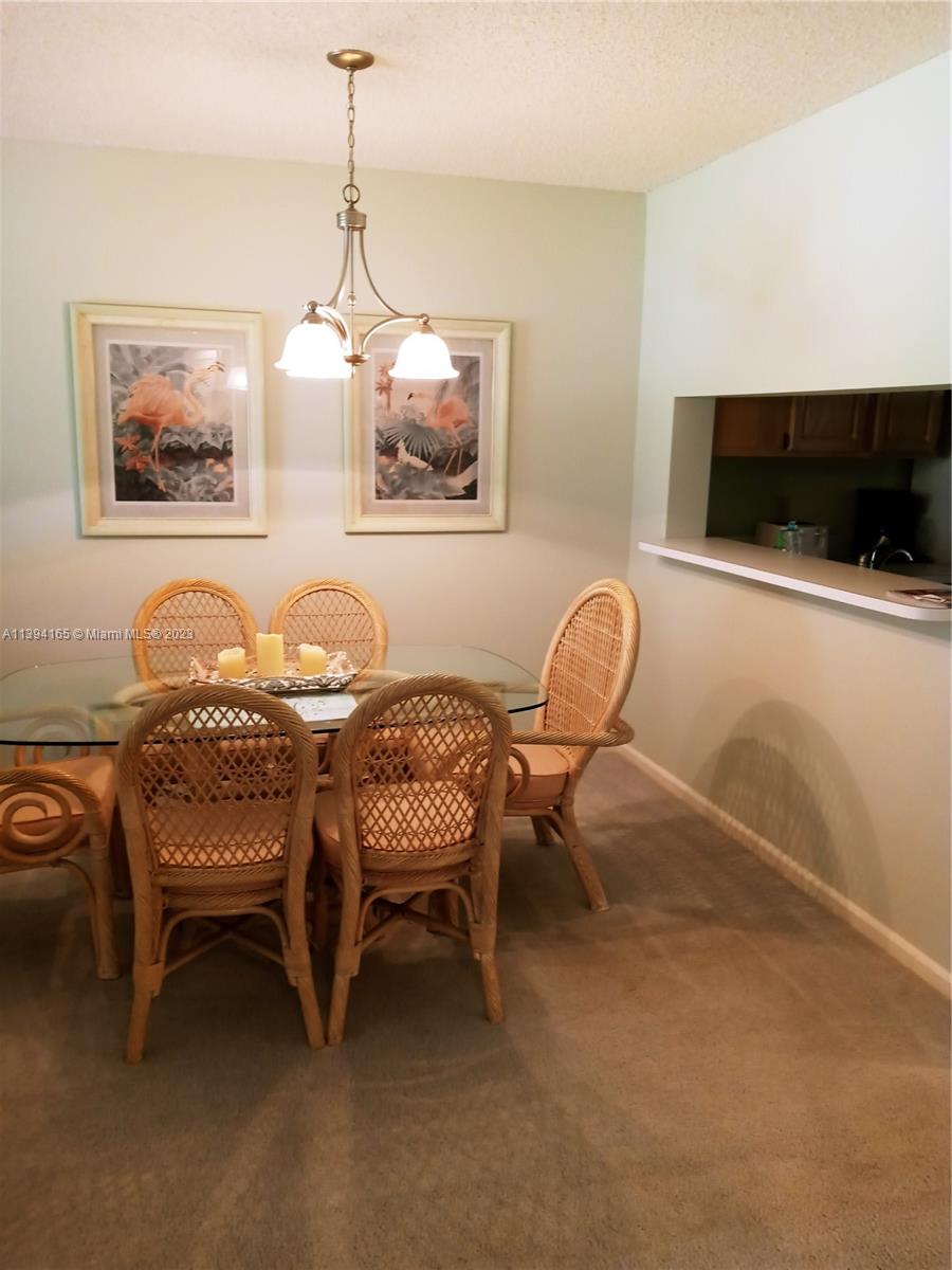 1081 Keystone Drive, Unit A Jupiter, FL 33458 - Photo 7 of 10 a dining room with furniture and a flat screen tv