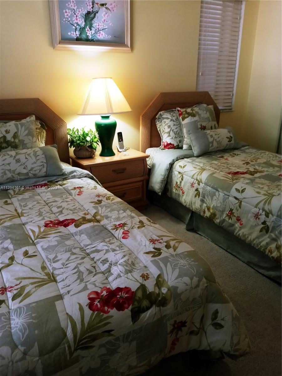 1081 Keystone Drive, Unit A Jupiter, FL 33458 - Photo 8 of 10 a bedroom with a bed and a painting on the wall