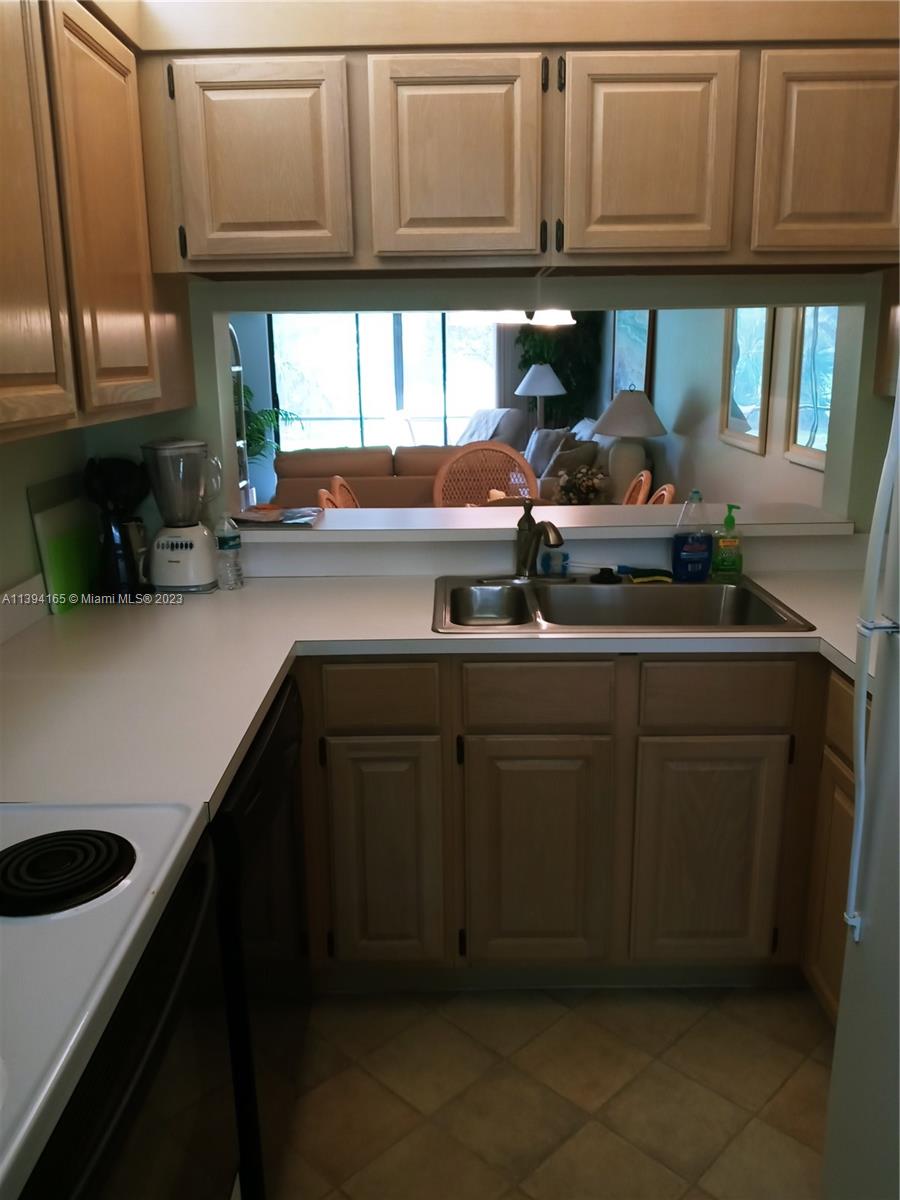 1081 Keystone Drive, Unit A Jupiter, FL 33458 - Photo 9 of 10 a kitchen with stainless steel appliances granite countertop a sink a stove and cabinets